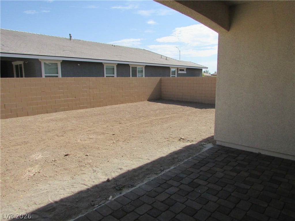 510 CHESTNUT FALCON AVE, Henderson, NV 89011 A spacious backyard awaits personalization, bordered by a privacy wall and leading to a shaded paver patio. Photo is Actual Home.