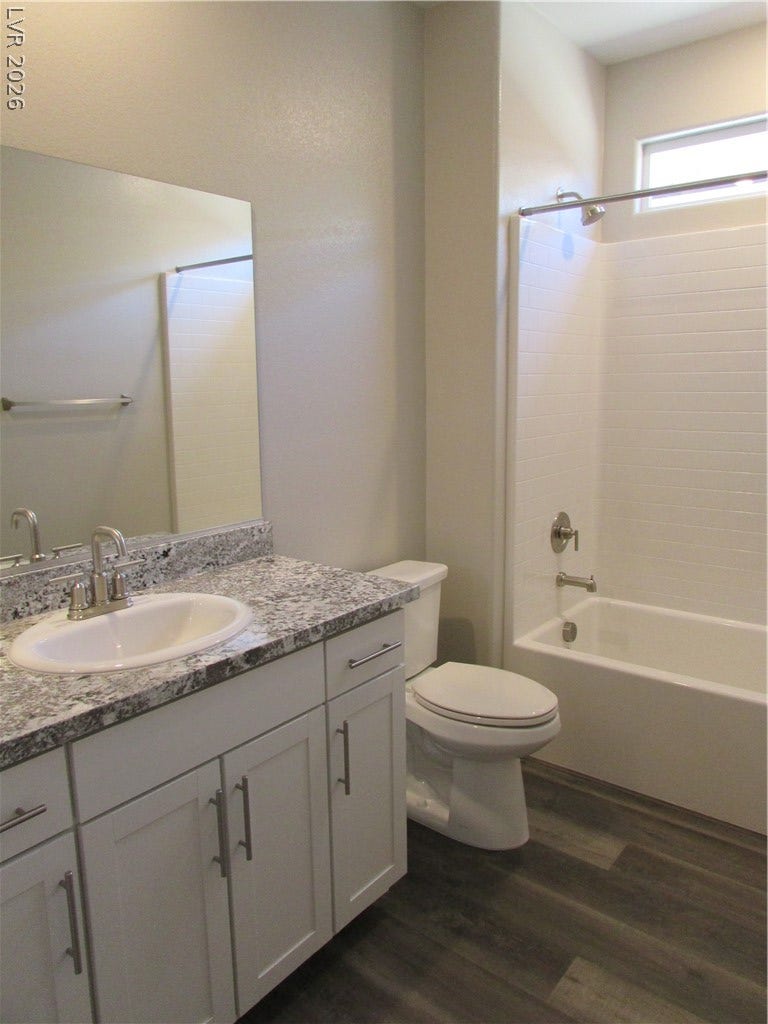 510 CHESTNUT FALCON AVE, Henderson, NV 89011 A well-lit primary bathroom features a double vanity with granite counters and a spacious shower.