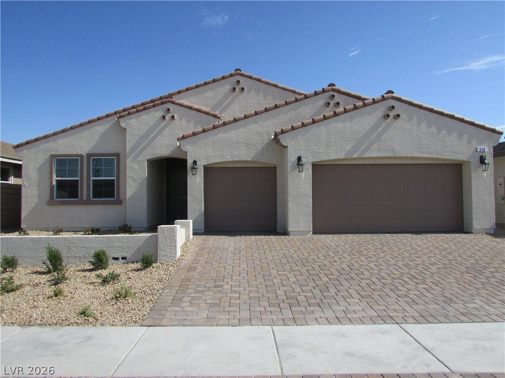 510 CHESTNUT FALCON AVE, Henderson, NV 89011 A well-maintained facade features a paver driveway, stucco finish, and an inviting entryway. Photo is Actual Home.