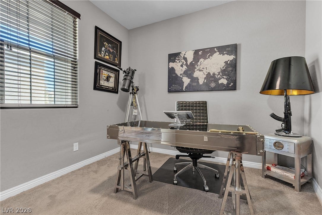 3106 Berceto Court, Henderson, NV 89044 A well-lit study with neutral carpeting and a unique industrial-style desk creates an inspiring workspace.