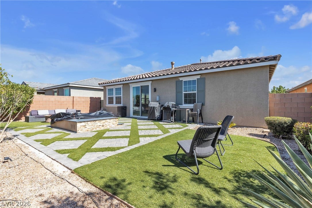3106 Berceto Court, Henderson, NV 89044 A private backyard oasis features an inviting outdoor patio with a fire pit and artificial turf.