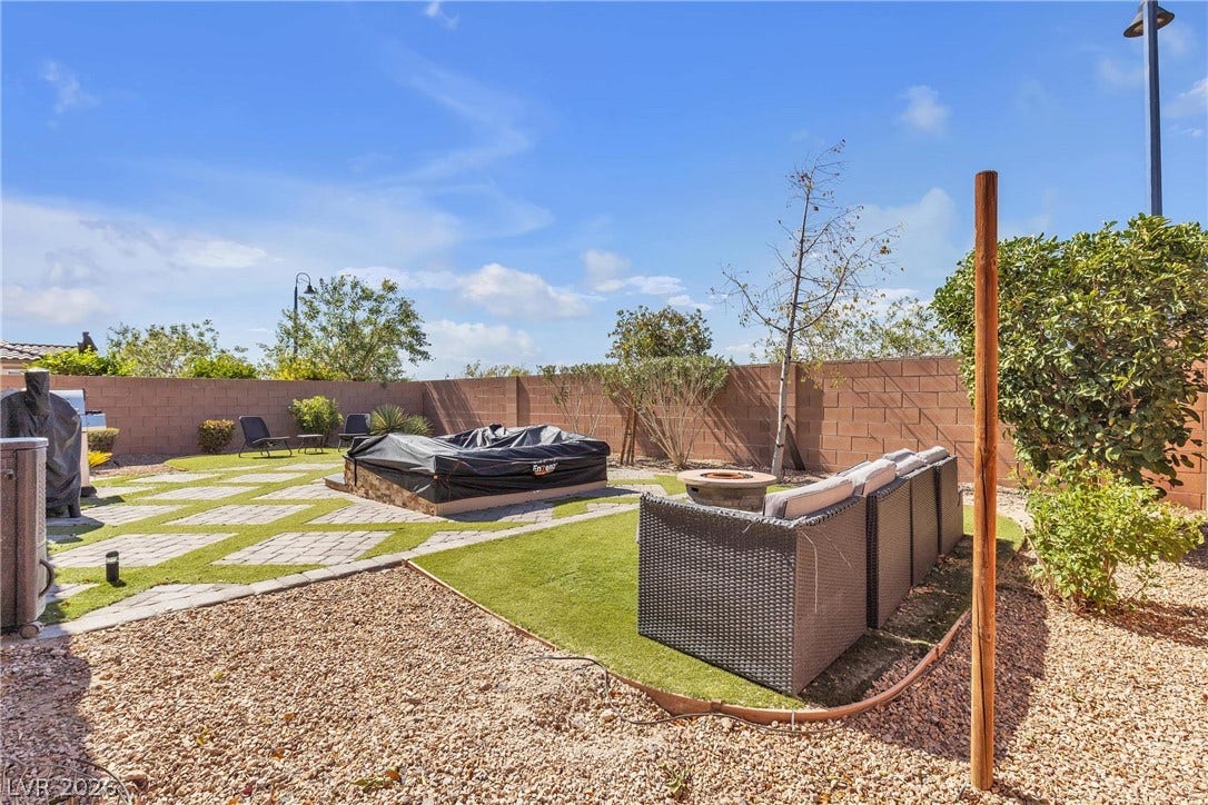 3106 Berceto Court, Henderson, NV 89044 A private yard with a fire pit, patio, and lush lawn offers an ideal outdoor retreat.