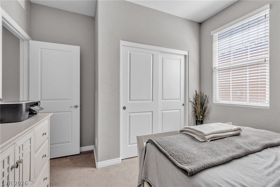 3106 Berceto Court, Henderson, NV 89044 A comfortable bedroom with soft carpeting and ample natural light through its window.