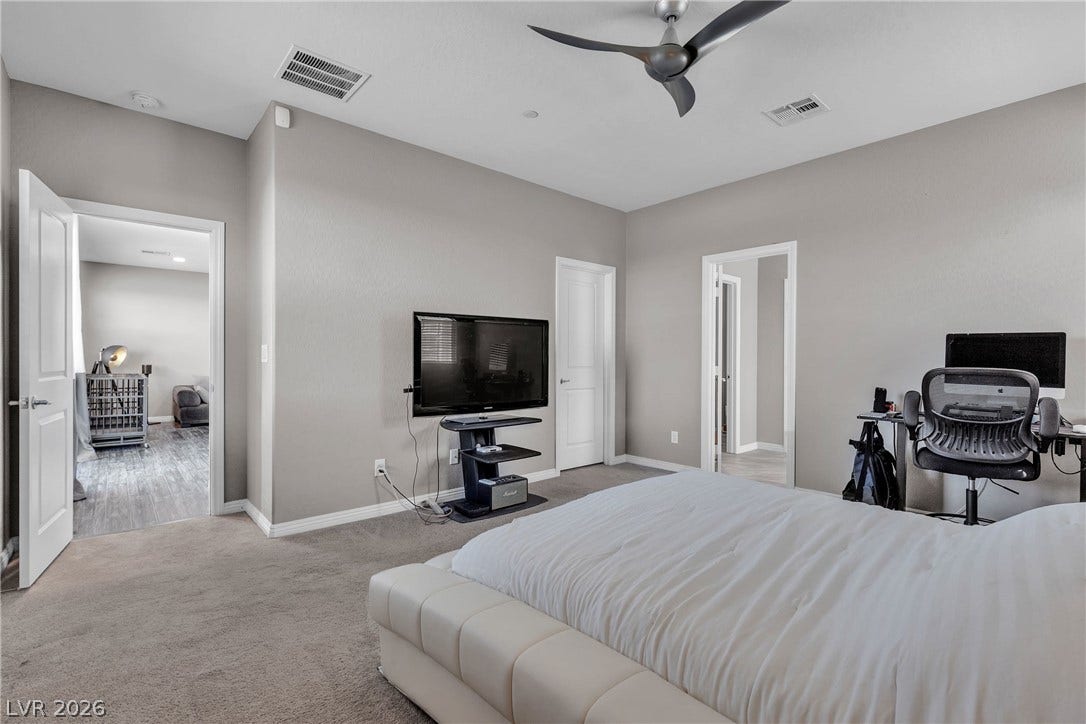 3106 Berceto Court, Henderson, NV 89044 A well-lit bedroom features plush carpeting and a modern ceiling fan for ultimate comfort.