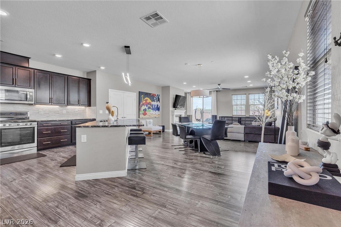 3106 Berceto Court, Henderson, NV 89044 An open-concept living space with sleek flooring connects a gourmet kitchen to a relaxed dining area.