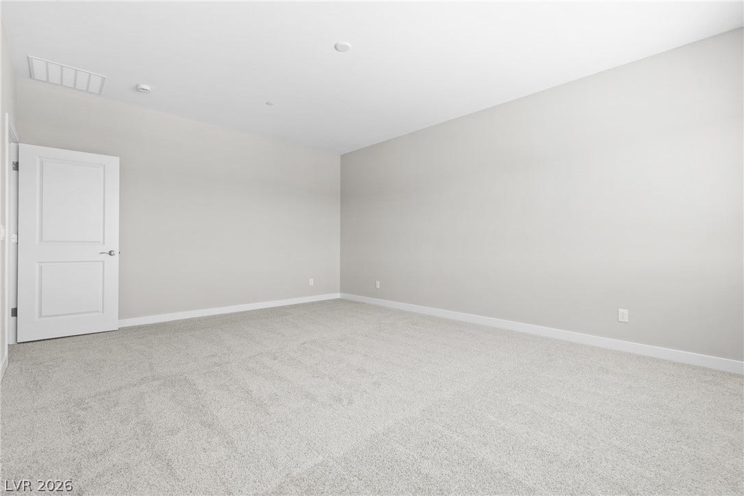 2405 Copperbelt Street, Las Vegas, NV 89030 A spacious room offers comfortable carpet flooring and fresh, neutral walls.