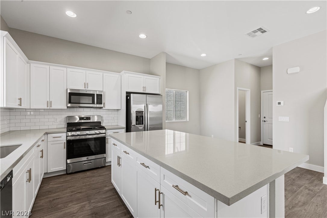 2405 Copperbelt Street, Las Vegas, NV 89030 Culinary dreams come alive in this kitchen, featuring an expansive island, sleek stainless appliances, and abundant cabinetry.