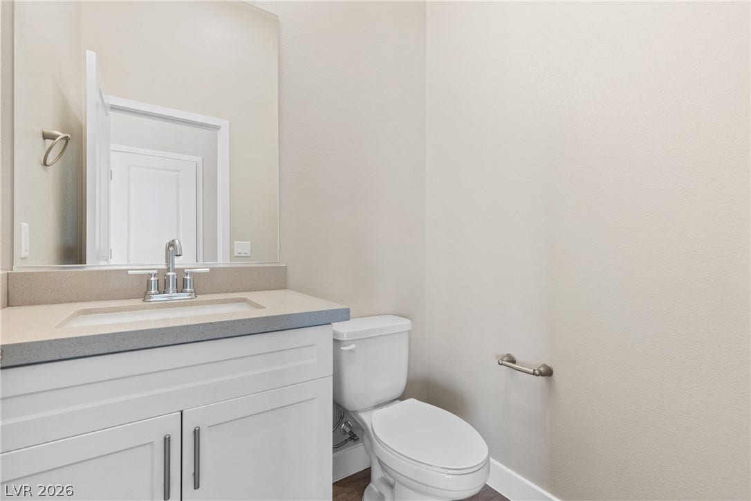 2405 Copperbelt Street, Las Vegas, NV 89030 A well-appointed half bath features a sleek vanity and convenient commode, perfect for guests.