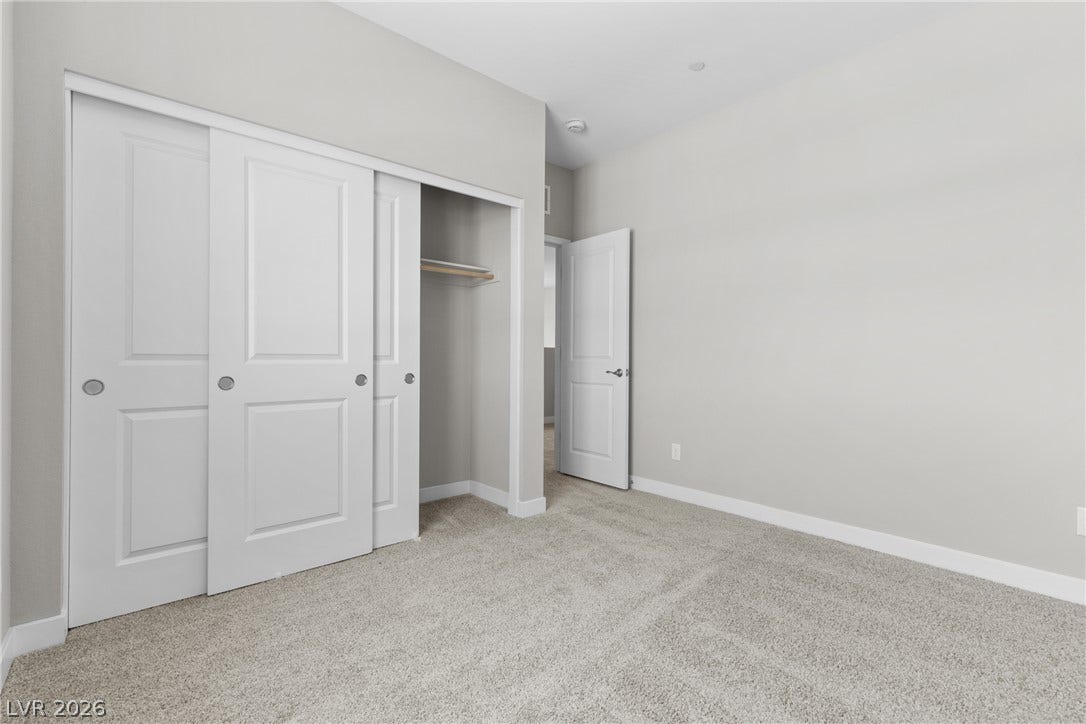 2405 Copperbelt Street, Las Vegas, NV 89030 A spacious bedroom features plush carpet flooring and a convenient sliding closet door.