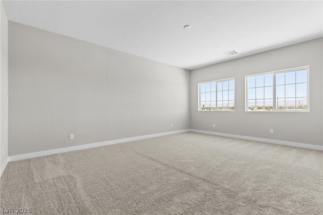 2405 Copperbelt Street, Las Vegas, NV 89030 A spacious room offers comfortable carpeting and views of the surrounding landscape through multiple windows.
