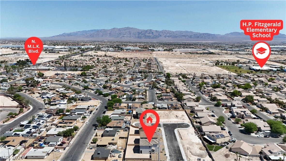 2405 Copperbelt Street, Las Vegas, NV 89030 An aerial perspective reveals a vibrant neighborhood with desert landscaping and mountainous backdrops.