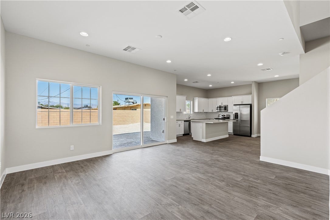 2405 Copperbelt Street, Las Vegas, NV 89030 An open floorplan seamlessly connects the living space to a modern kitchen, featuring sleek appliances.