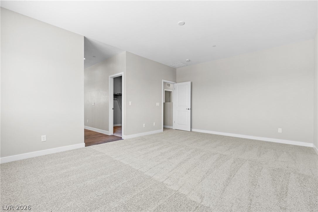 2405 Copperbelt Street, Las Vegas, NV 89030 A spacious, neutral-toned room with plush carpeting offers versatile living possibilities.