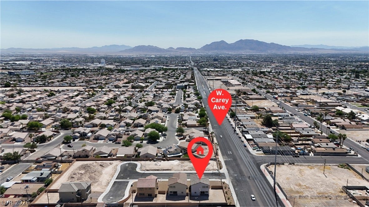 2405 Copperbelt Street, Las Vegas, NV 89030 An aerial perspective showcases a vibrant urban landscape against a distant mountain range.