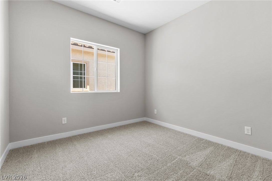 2405 Copperbelt Street, Las Vegas, NV 89030 A spacious, naturally illuminated room featuring plush carpeting and a large window.