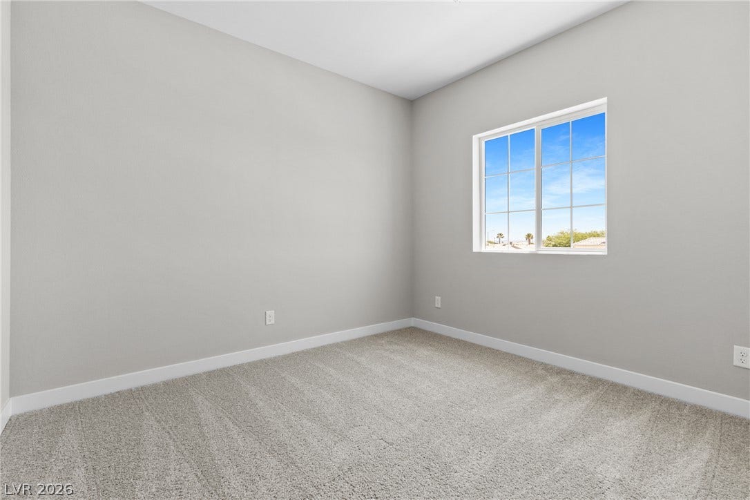 2405 Copperbelt Street, Las Vegas, NV 89030 A well-proportioned bedroom offers soft carpeting and a window providing a pleasant outdoor perspective.