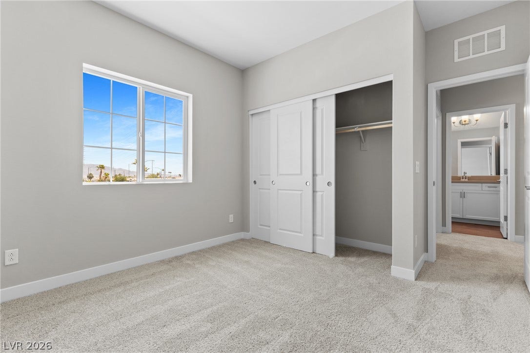 2405 Copperbelt Street, Las Vegas, NV 89030 A well-lit bedroom with a bright window, ample closet space, and soft carpeting.