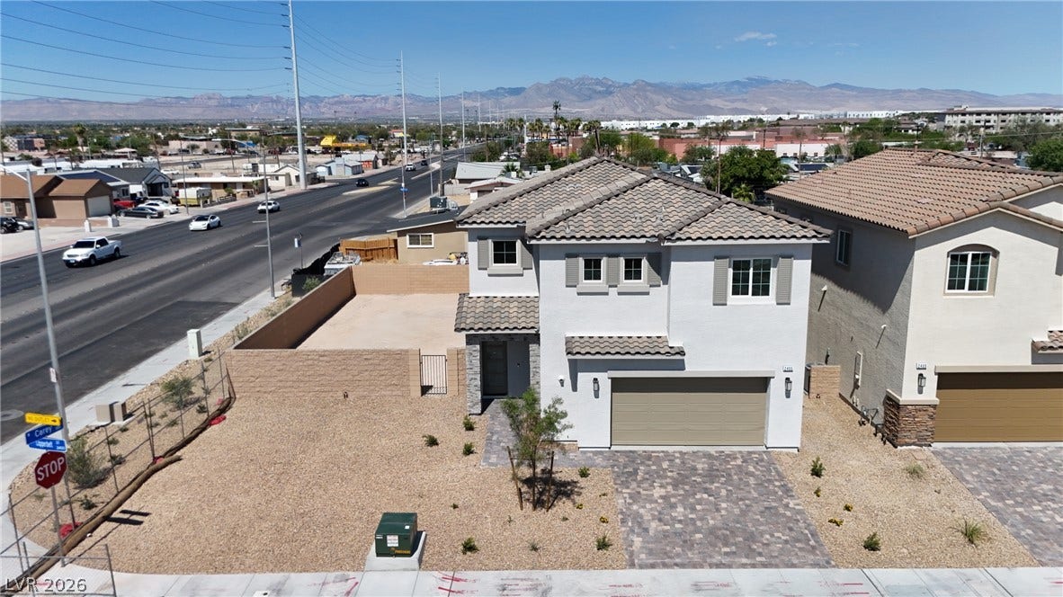 2405 Copperbelt Street, Las Vegas, NV 89030 A newly constructed residence features an attached garage and a neatly paved driveway.
