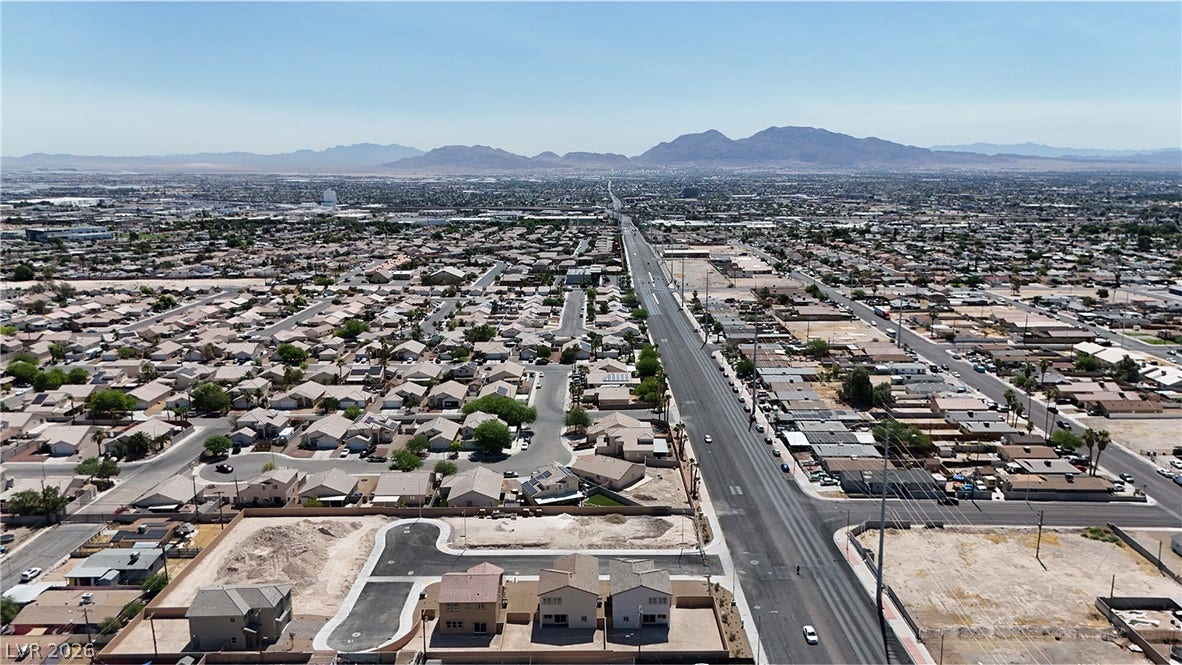 2405 Copperbelt Street, Las Vegas, NV 89030 An aerial perspective reveals a vast urban landscape stretching towards distant mountains under a clear sky.