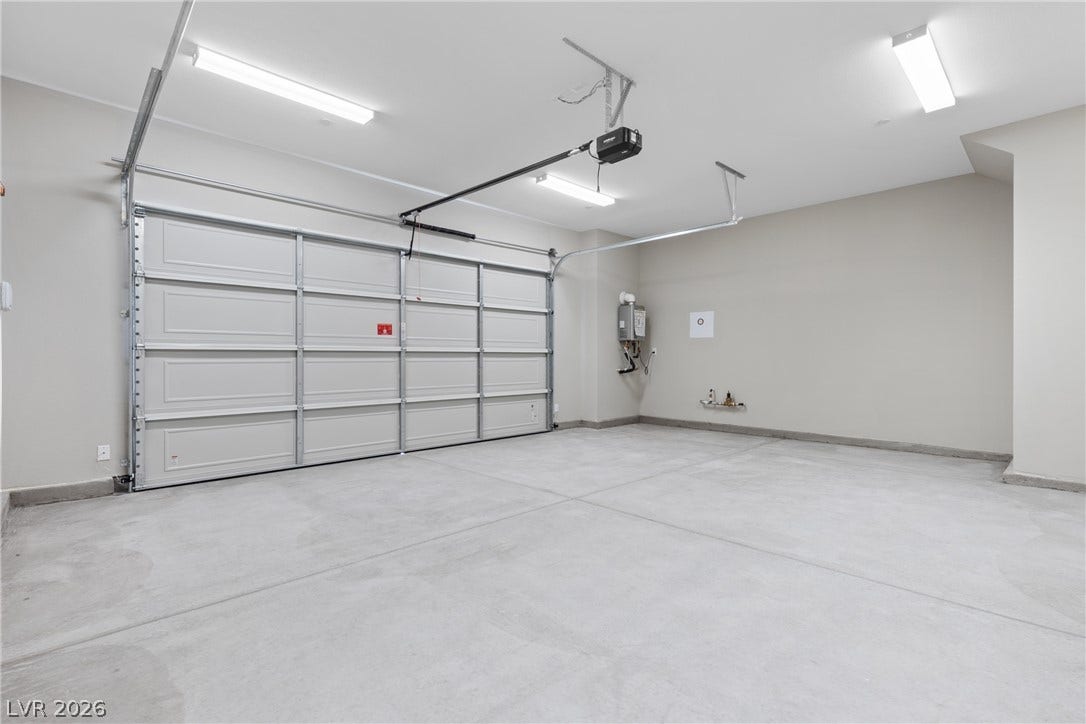 2405 Copperbelt Street, Las Vegas, NV 89030 A spacious, newly finished garage with a full door and overhead lighting.