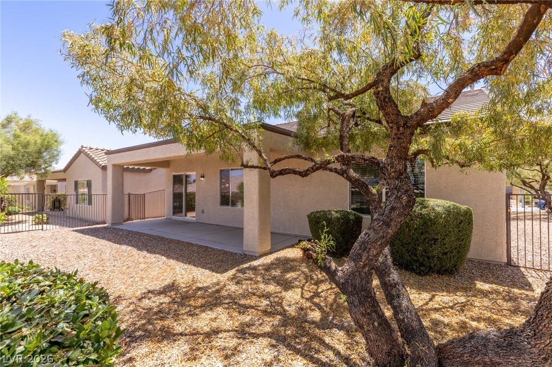 2157 Sawtooth Mountain Drive, Henderson, NV 89044 A covered patio in the low maintenance backyard oasis with mature trees provides ample space for relaxation and entertaining.