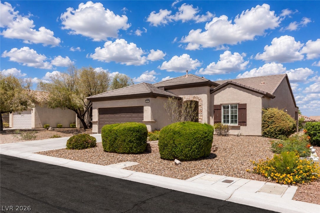 2157 Sawtooth Mountain Drive, Henderson, NV 89044 Discover a charming stucco exterior and neatly landscaped desert garden under a vibrant sky.