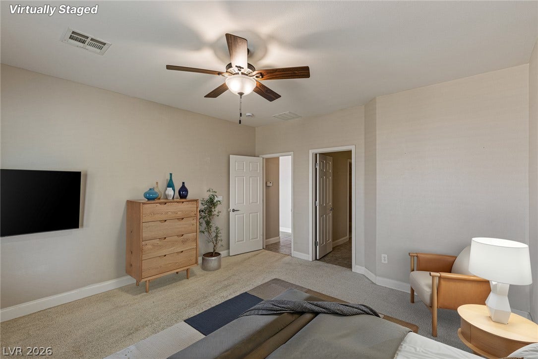 2157 Sawtooth Mountain Drive, Henderson, NV 89044 Ensuite primary bedroom with adjacent bath, large windows and ceiling fan for comfort.
