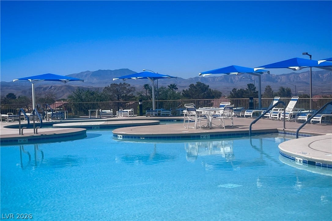 2157 Sawtooth Mountain Drive, Henderson, NV 89044 A refreshing pool area with sunshades and loungers, offering sweeping mountain views.