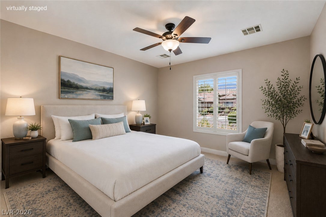 2157 Sawtooth Mountain Drive, Henderson, NV 89044 A well-lit bedroom features a cozy bed, ceiling fan, and a wide window offering pleasant neighborhood views.