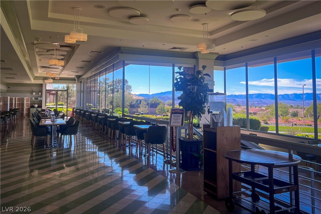 2157 Sawtooth Mountain Drive, Henderson, NV 89044 Floor-to-ceiling windows frame sweeping mountain views, illuminating a stylish dining area.