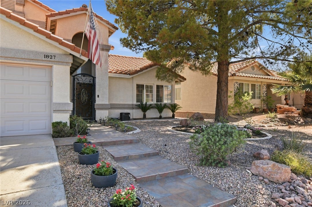 1827 Escondido Terrace, Henderson, NV 89074 A terracotta-roofed residence welcomes with a tiled pathway and meticulously landscaped xeriscape yard.