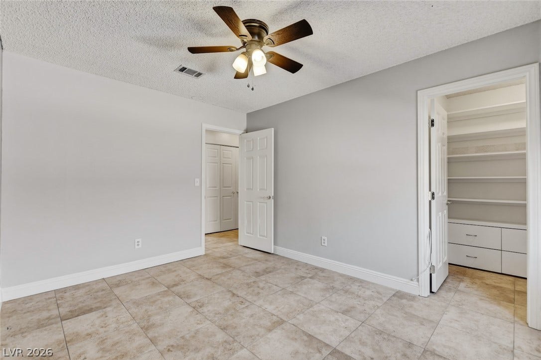 1827 Escondido Terrace, Henderson, NV 89074 A well-lit bedroom offering ample storage with a walk-in closet and easy-care tile flooring.