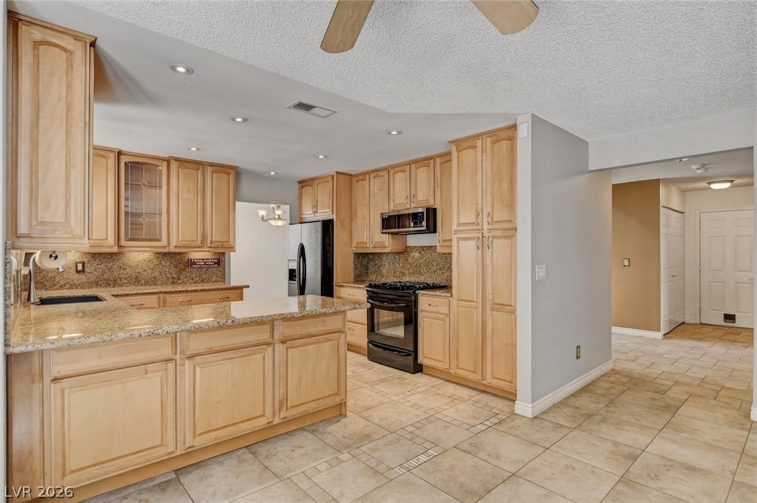 1827 Escondido Terrace, Henderson, NV 89074 Ample cabinetry and stone countertops elevate this well-appointed kitchen, offering both style and functionality.