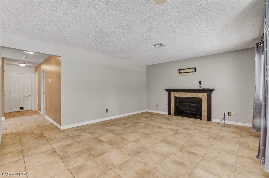 1827 Escondido Terrace, Henderson, NV 89074 A cozy living space awaits, featuring a prominent fireplace as its focal point.