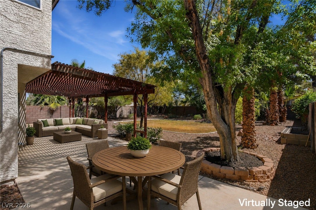 1827 Escondido Terrace, Henderson, NV 89074 A spacious concrete patio offers ample room for outdoor dining and relaxation beneath a charming wooden pergola.