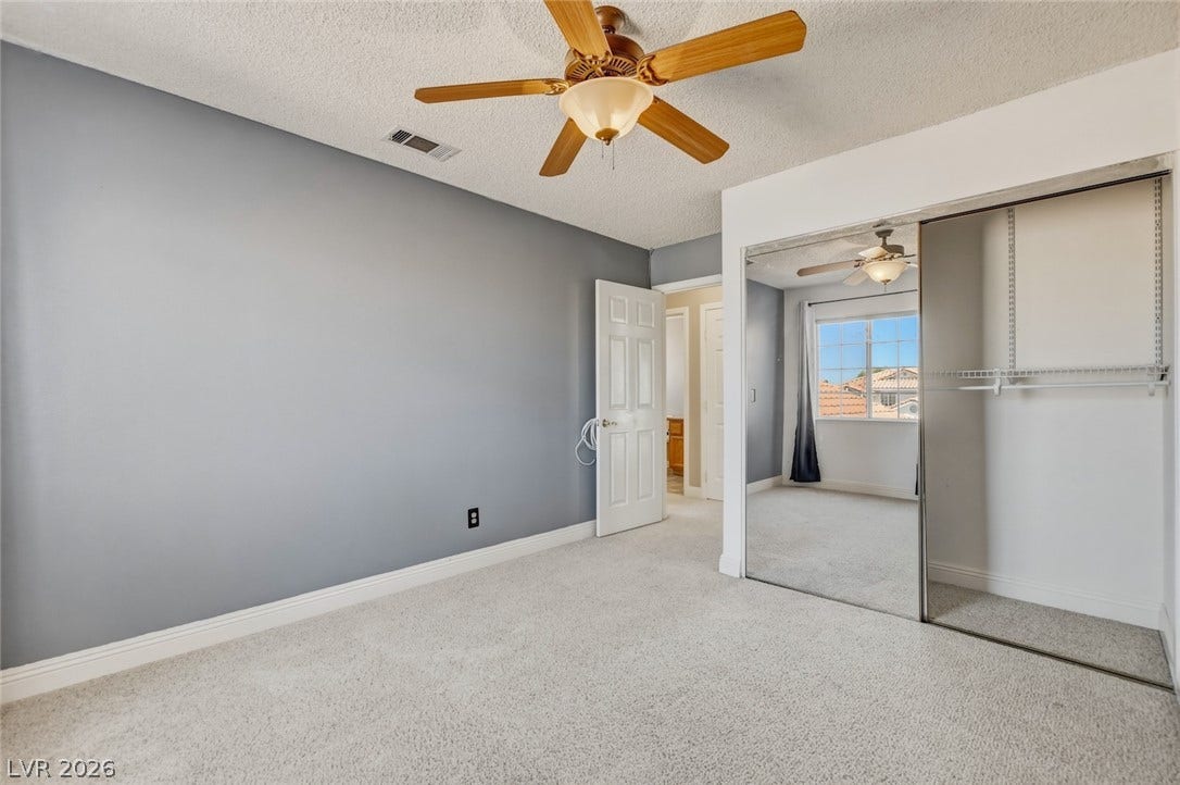 1827 Escondido Terrace, Henderson, NV 89074 An airy bedroom with a ceiling fan offers comfort and practicality, complete with mirrored closet doors.
