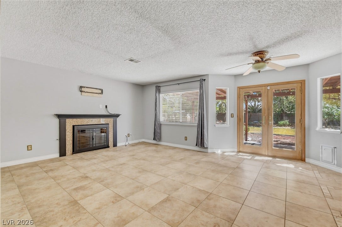 1827 Escondido Terrace, Henderson, NV 89074 A well-lit great room features a cozy fireplace and direct backyard access through French doors.