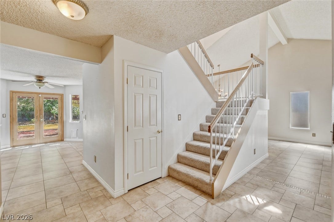 1827 Escondido Terrace, Henderson, NV 89074 A grand staircase with wrought iron balusters gracefully ascends from the tiled entry.