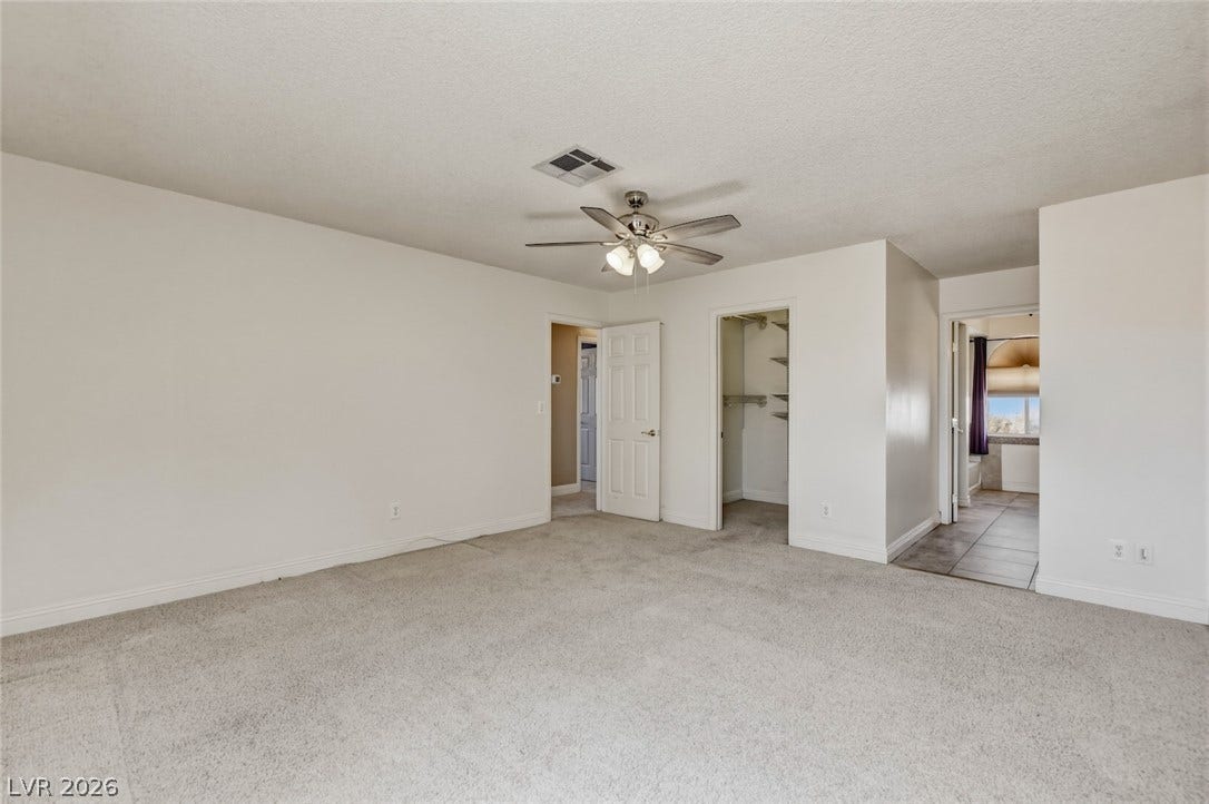 1827 Escondido Terrace, Henderson, NV 89074 A spacious bedroom offers plush carpeting, a walk-in closet, and convenient access to a private bathroom.