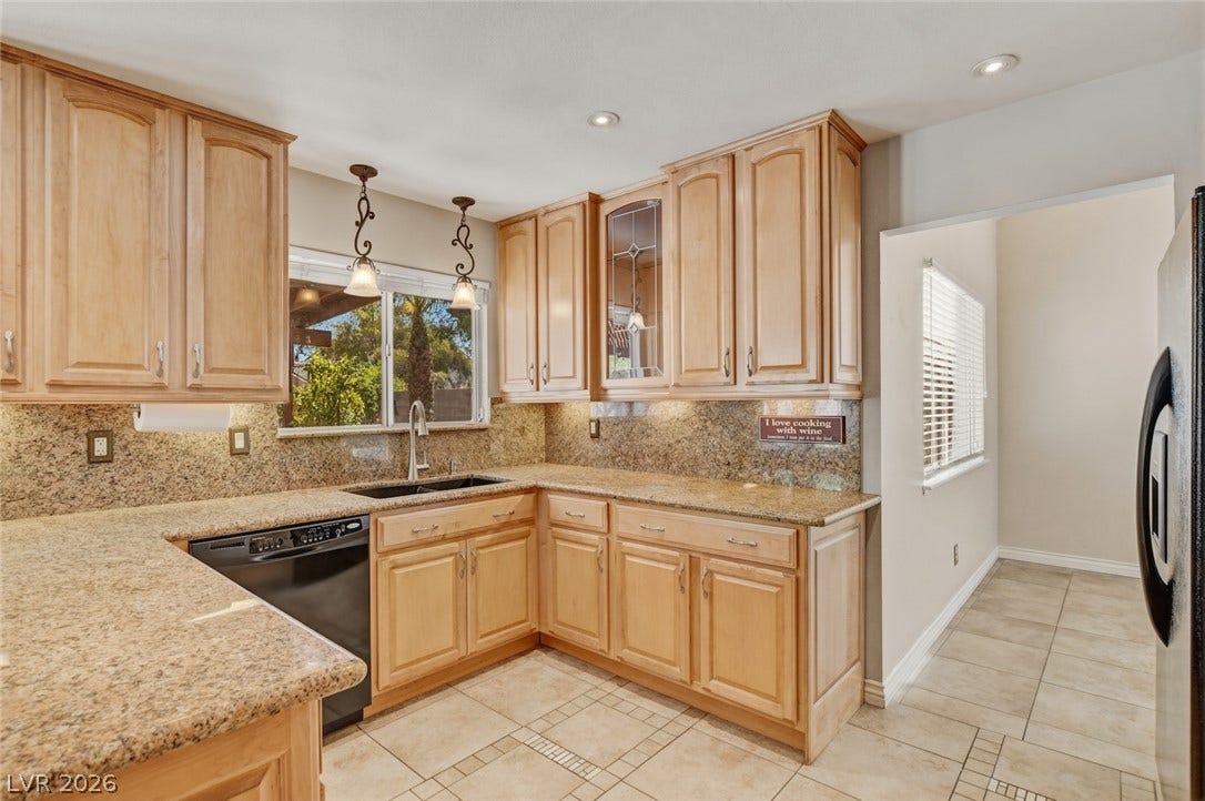 1827 Escondido Terrace, Henderson, NV 89074 Well-lit kitchen with generous countertop space and ample wood cabinetry.