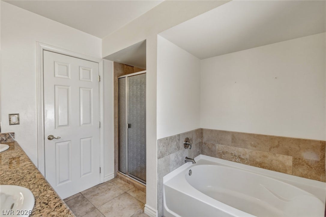 1827 Escondido Terrace, Henderson, NV 89074 A corner soaking tub and glass-enclosed shower create a serene bathing experience.