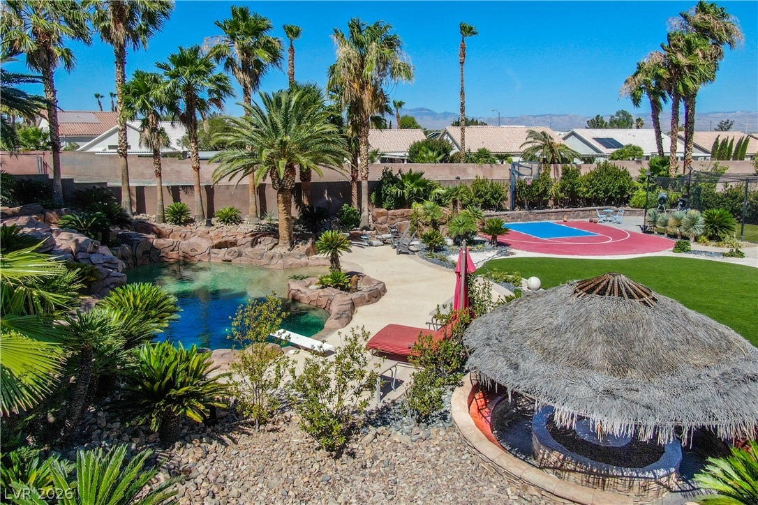 699 Brandy Hill Place, Henderson, NV 89052 An oasis awaits with a rock-lined pool, lush landscaping, and a private basketball court.