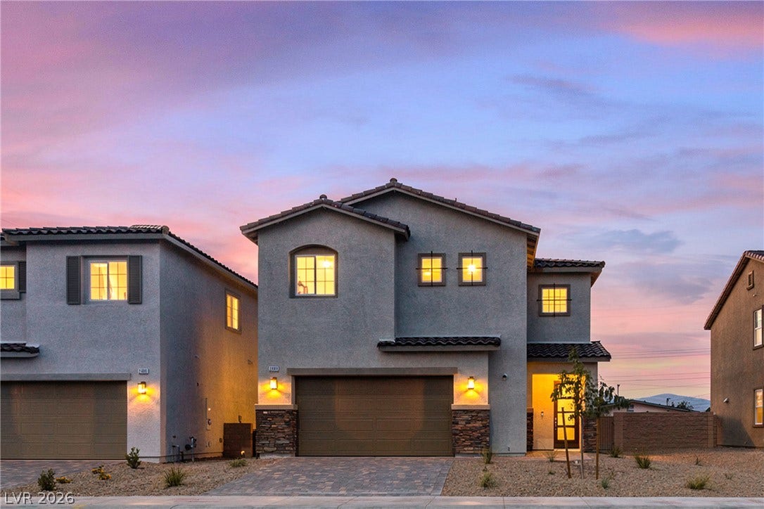 A modern exterior showcases stucco construction, clean architectural lines, and stone accents under dusk skies.