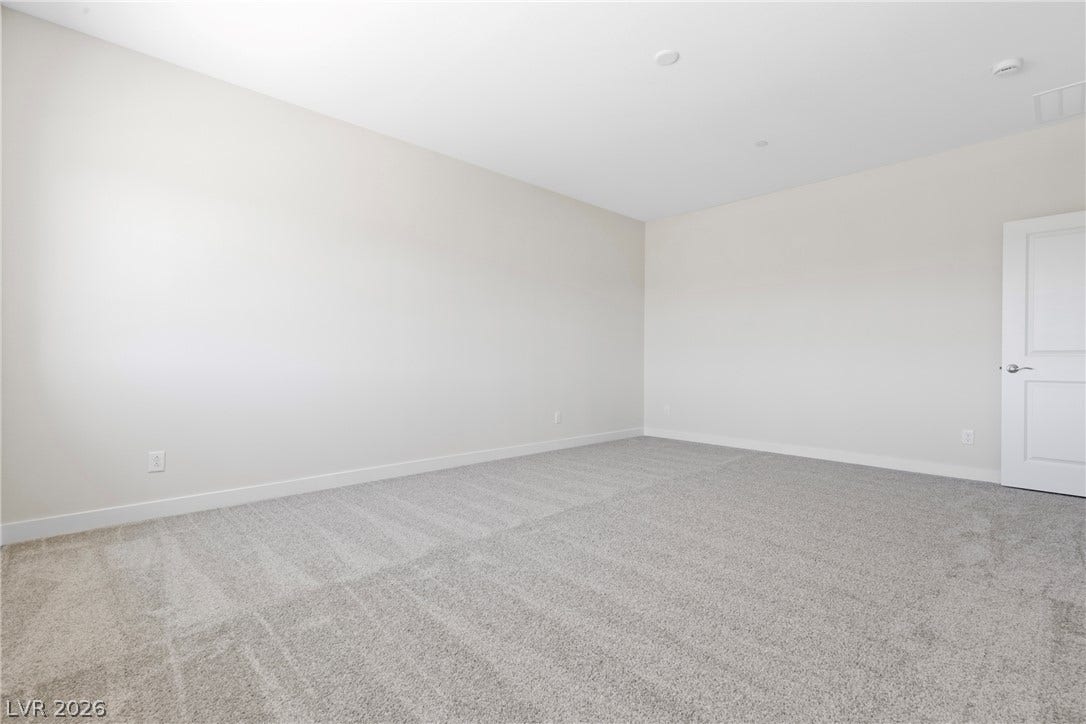 Soft carpeting pairs with smooth neutral walls in this versatile, light-filled interior space.