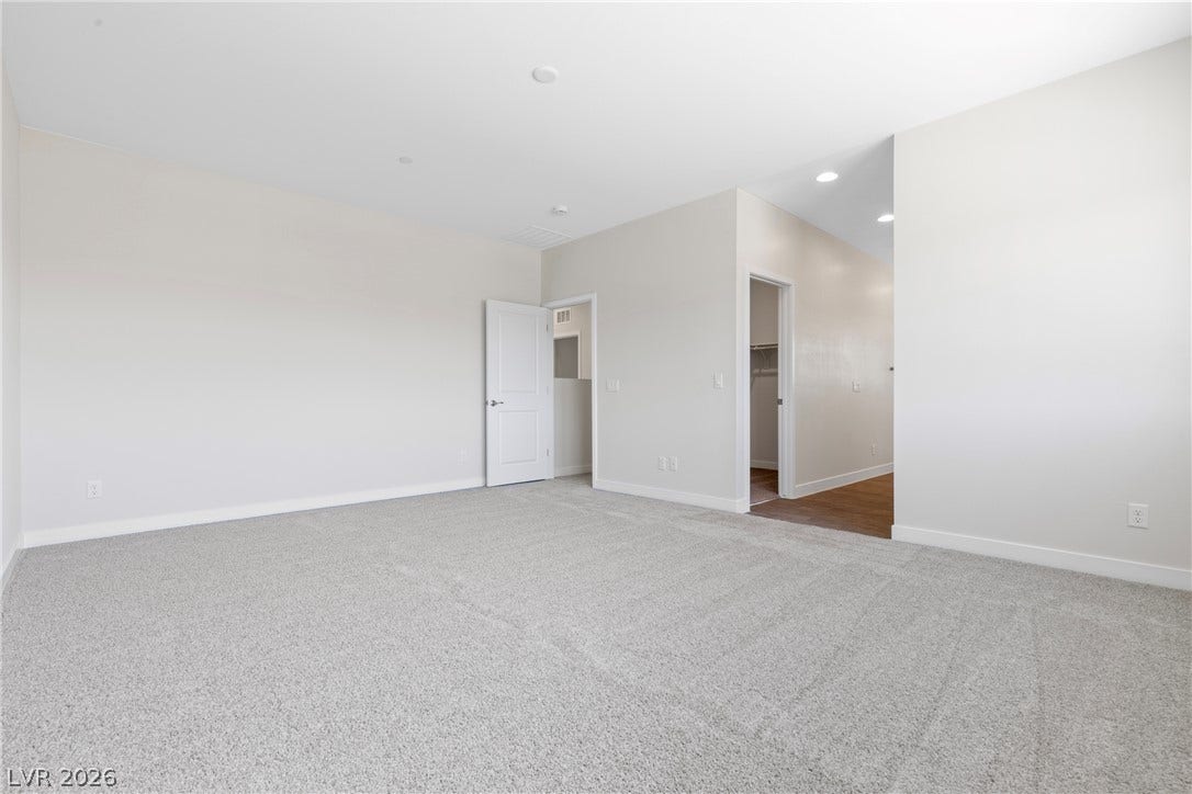 Plush wall-to-wall carpeting and clean neutral walls anchor this versatile secondary bedroom space.