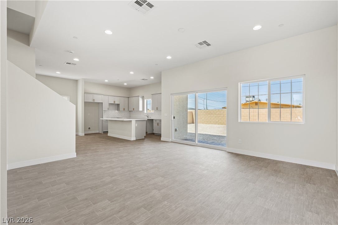 Recessed lighting and wood-look tile floors enrich this modern open living space.