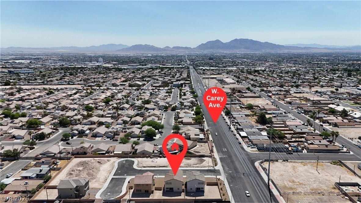 An aerial perspective captures the neighborhood setting with mountain ridges framing the distant horizon.