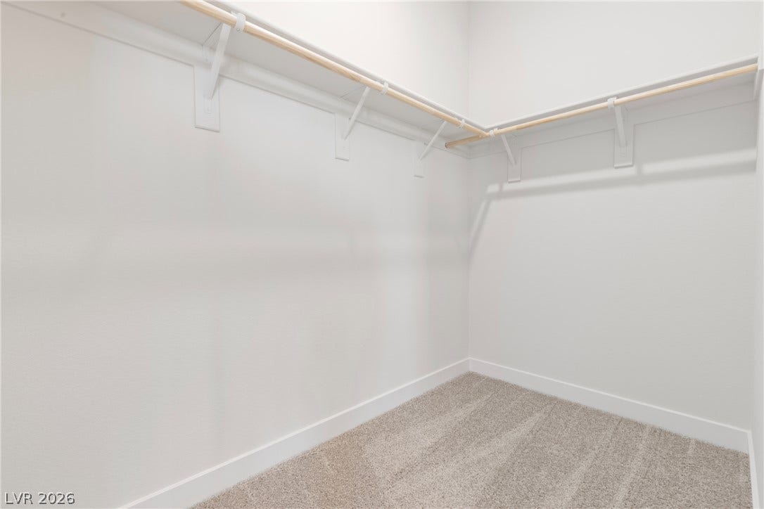 Generous hanging rods and built-in shelving maximize storage space over plush carpeting.