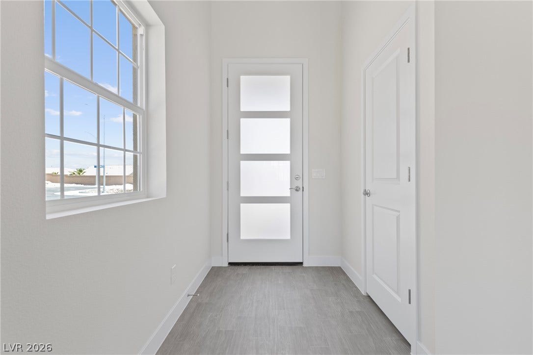 Natural light pours through a multi-pane window into this clean, welcoming entryway.