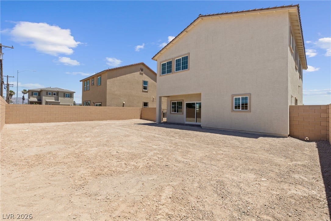 An expansive backyard space enclosed by block walls awaits personalized landscaping design.